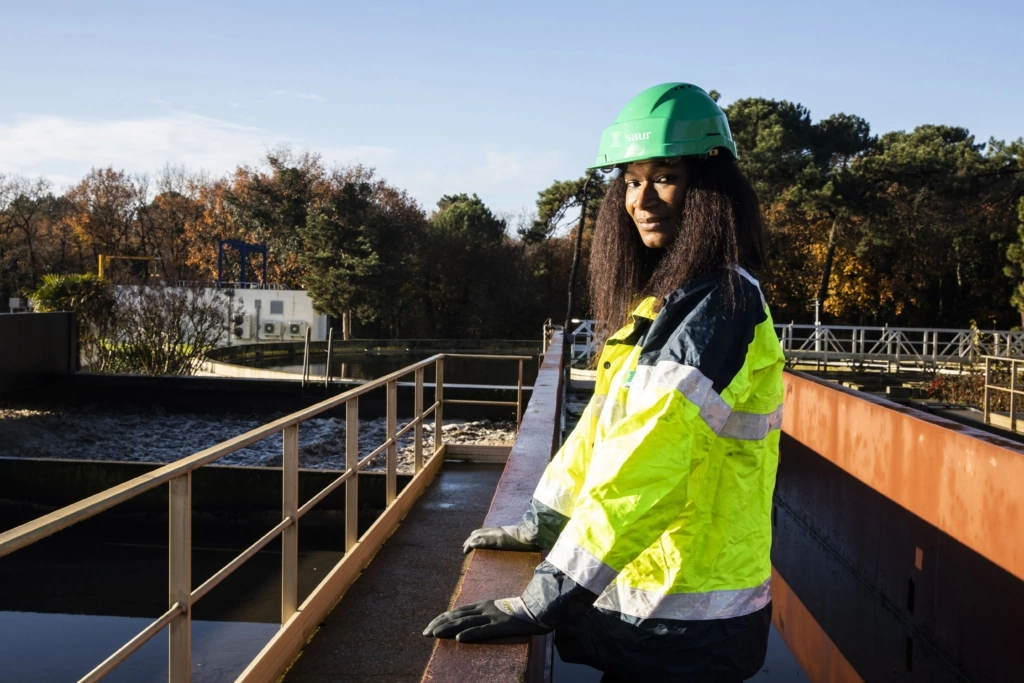 A woman standing on a wastewater treatment plant in uniform