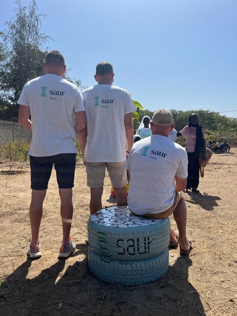 three Saur employees wearing t-shirt with Saur logo in the desert