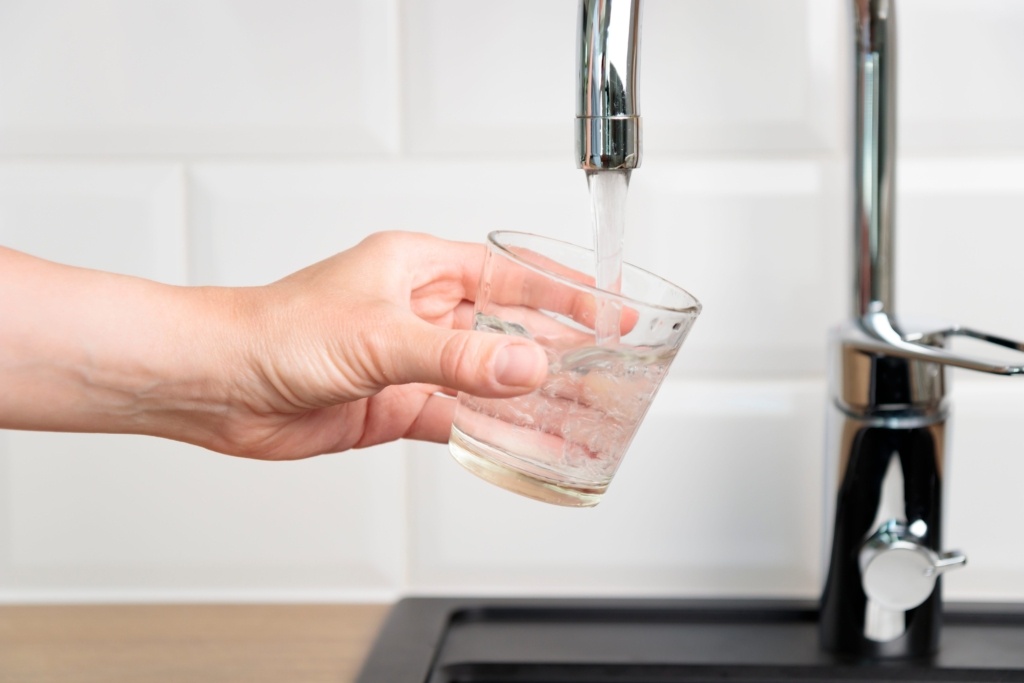 Water glass being filled from tap